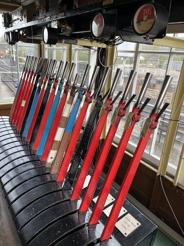 A photo of a signal box lever frame showing a variety of lever colours